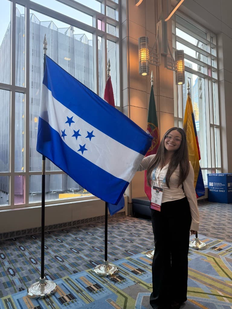 Sam at SHPE National Convention holding the Honduras flag